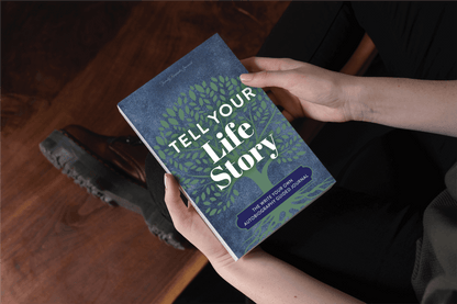 The book Tell Your Life Story being held by two hands.